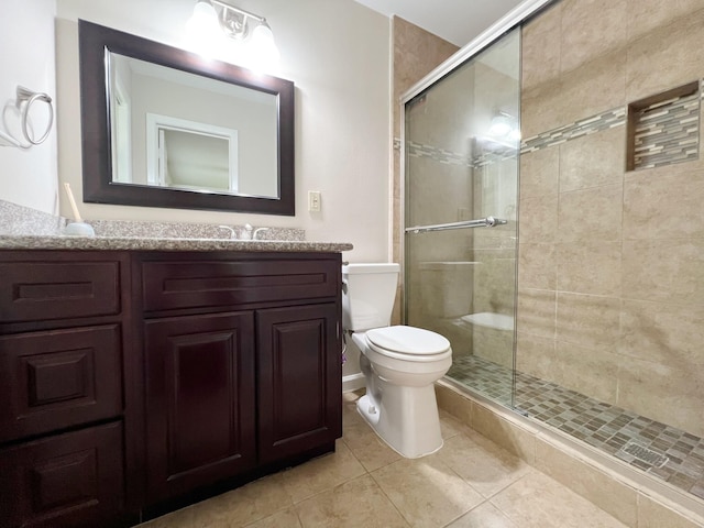 bathroom featuring vanity, tile patterned flooring, a stall shower, and toilet