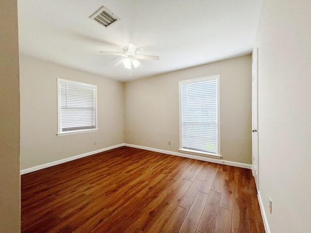 spare room with visible vents, baseboards, ceiling fan, and wood finished floors