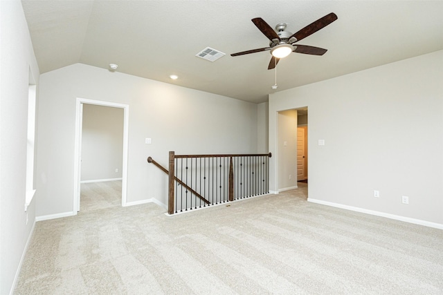 unfurnished room with a ceiling fan, baseboards, light colored carpet, and vaulted ceiling