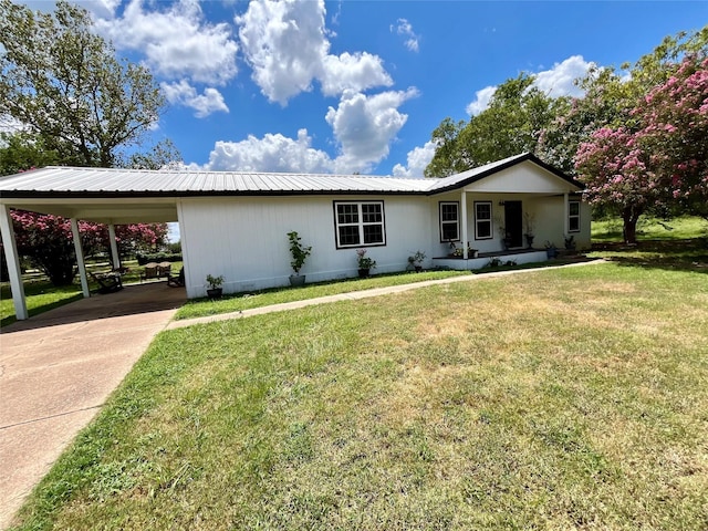 single story home with a front lawn, metal roof, concrete driveway, a porch, and a carport