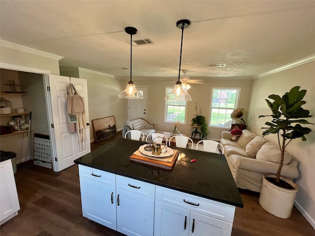 kitchen featuring dark wood-style flooring, dark countertops, and ornamental molding