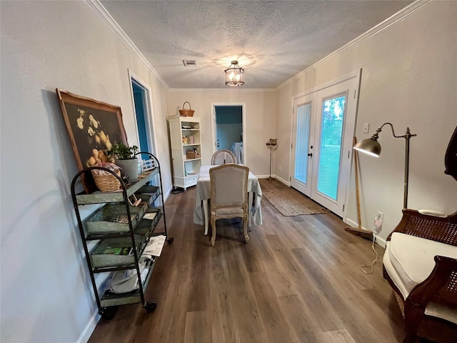 dining room with crown molding, a textured ceiling, and dark wood finished floors