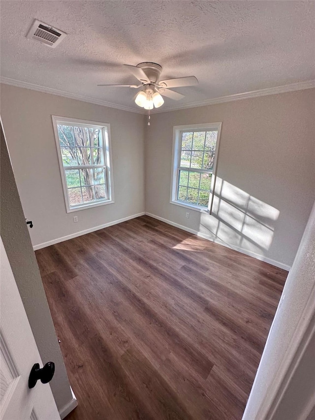 empty room featuring crown molding, a textured ceiling, and visible vents