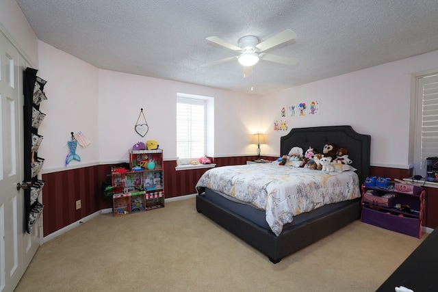 5503 Pebble Springs Dr, Houston, TX 77066 - carpeted bedroom featuring wainscoting, a textured ceiling, wood walls, and ceiling fan