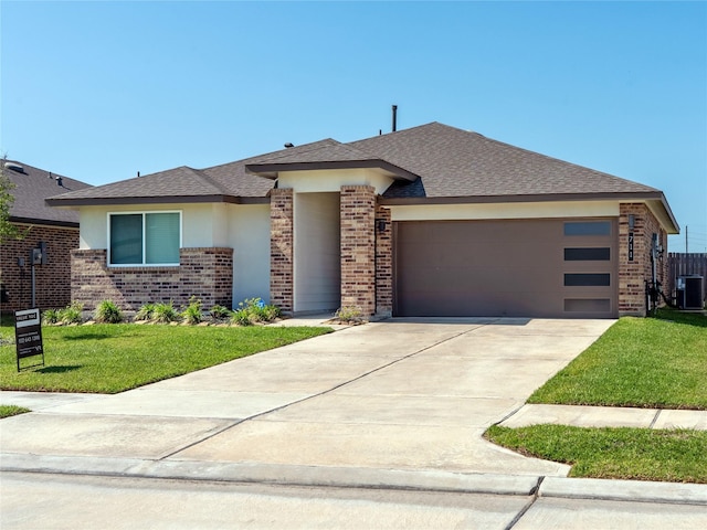 711 Boer Plains Dr, Rosharon, TX 77583 - prairie-style house with brick siding, an attached garage, concrete driveway, a front lawn, and stucco siding