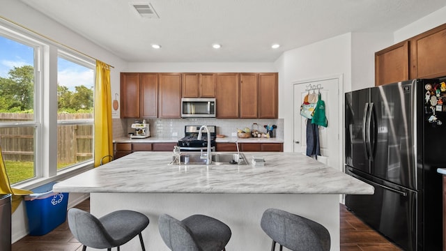 6630 Elks Trce, Richmond, TX 77406 - kitchen with a kitchen breakfast bar, appliances with stainless steel finishes, decorative backsplash, and visible vents