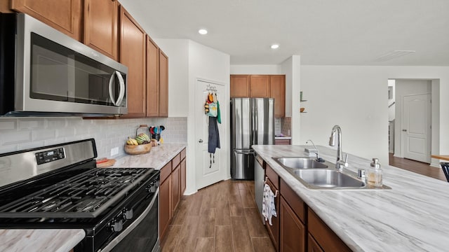 6630 Elks Trce, Richmond, TX 77406 - kitchen featuring a sink, brown cabinetry, stainless steel appliances, decorative backsplash, and dark wood-style floors