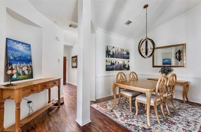 dining room featuring a chandelier, dark wood-style flooring, crown molding, and baseboards