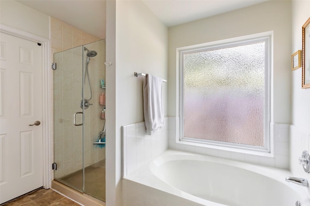 bathroom with plenty of natural light, a shower stall, and a bath