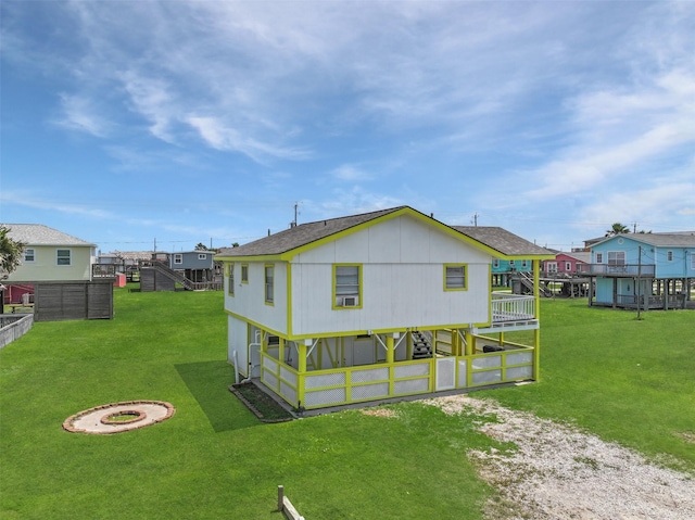 rear view of house with a residential view, a shingled roof, and a yard