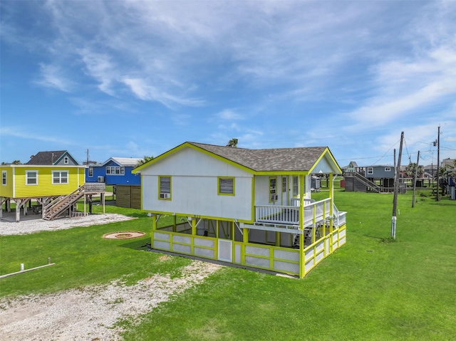 rear view of house featuring a lawn, a wooden deck, a residential view, an outdoor fire pit, and stairs