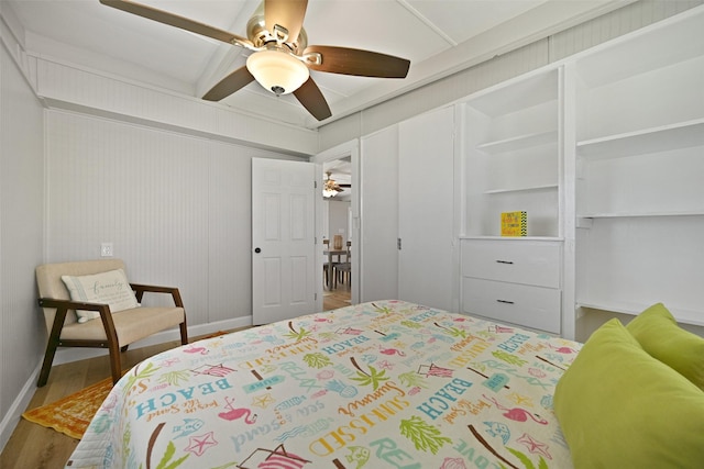 bedroom featuring a ceiling fan, baseboards, wood finished floors, and a closet