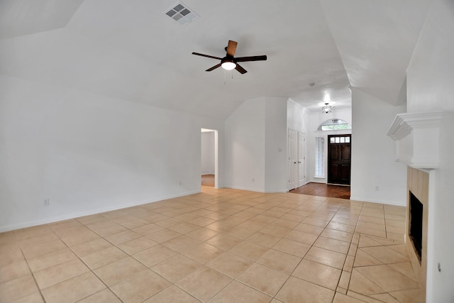 67 N Winterport Cir, The Woodlands, TX 77382 - unfurnished living room featuring light tile patterned flooring, ceiling fan, vaulted ceiling, and a fireplace