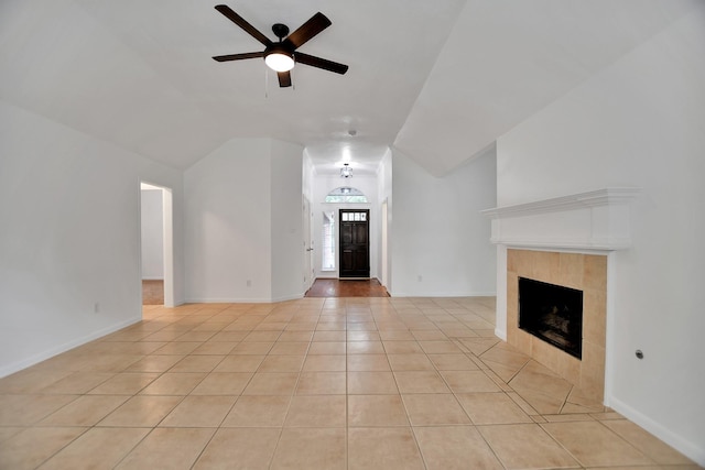 67 N Winterport Cir, The Woodlands, TX 77382 - unfurnished living room featuring a ceiling fan, lofted ceiling, light tile patterned floors, a tile fireplace, and baseboards