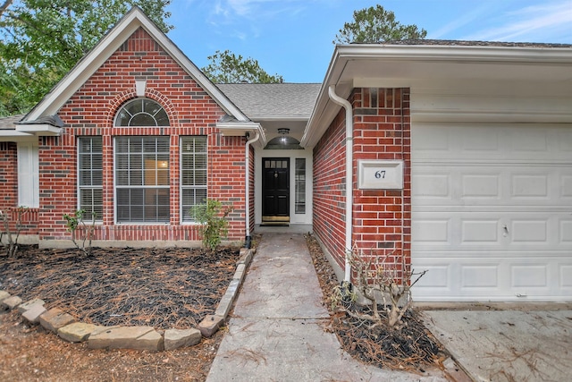 67 N Winterport Cir, The Woodlands, TX 77382 - property entrance with brick siding, an attached garage, and a shingled roof