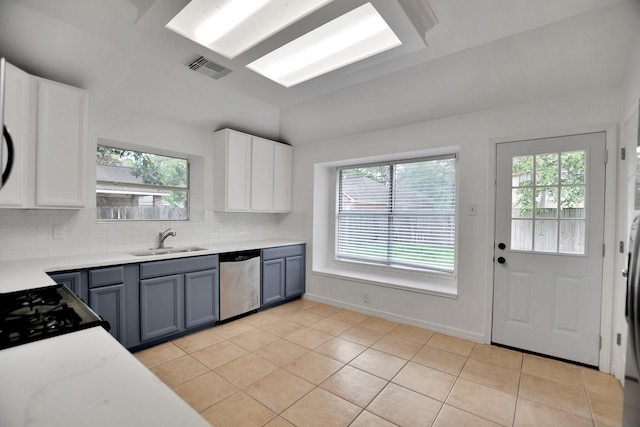 67 N Winterport Cir, The Woodlands, TX 77382 - kitchen featuring stainless steel dishwasher, a sink, plenty of natural light, tasteful backsplash, and vaulted ceiling