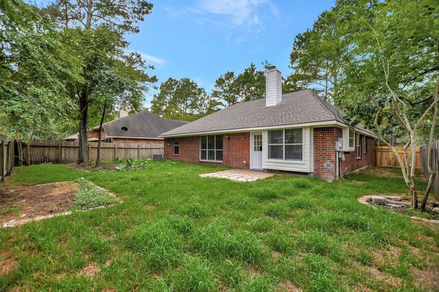 67 N Winterport Cir, The Woodlands, TX 77382 - back of house with brick siding, a chimney, central AC unit, a patio area, and a shingled roof