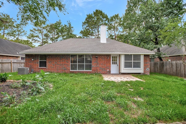 67 N Winterport Cir, The Woodlands, TX 77382 - rear view of house featuring a patio, central air condition unit, brick siding, and a chimney