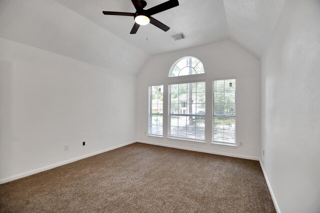 67 N Winterport Cir, The Woodlands, TX 77382 - spare room with dark carpet, a ceiling fan, vaulted ceiling, and baseboards