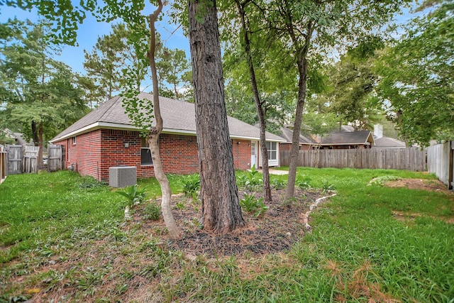 67 N Winterport Cir, The Woodlands, TX 77382 - view of side of home with brick siding, a shingled roof, and central air condition unit