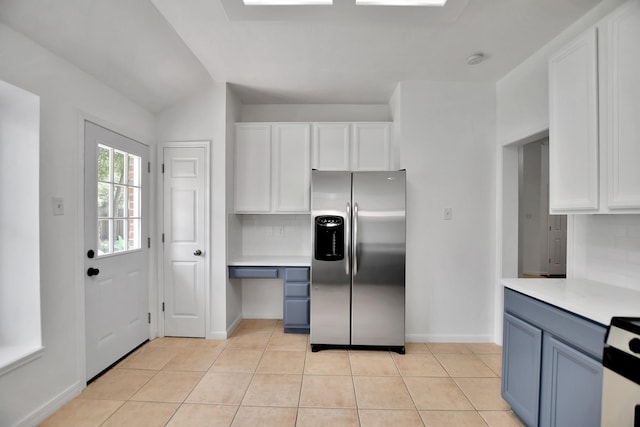67 N Winterport Cir, The Woodlands, TX 77382 - kitchen with stainless steel fridge with ice dispenser, light countertops, decorative backsplash, white cabinetry, and baseboards