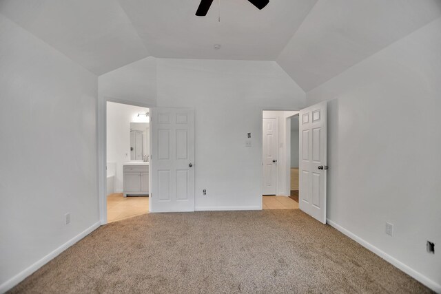 67 N Winterport Cir, The Woodlands, TX 77382 - unfurnished bedroom with light colored carpet, lofted ceiling, connected bathroom, baseboards, and ceiling fan
