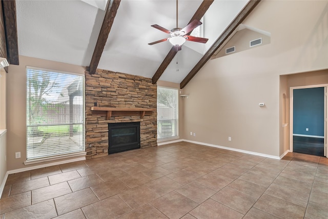 23106 Willow Canyon Dr, Katy, TX 77494 - unfurnished living room featuring ceiling fan, plenty of natural light, beam ceiling, a stone fireplace, and baseboards