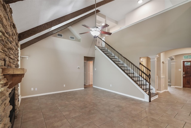 23106 Willow Canyon Dr, Katy, TX 77494 - unfurnished living room featuring high vaulted ceiling, ornate columns, a ceiling fan, a stone fireplace, and arched walkways