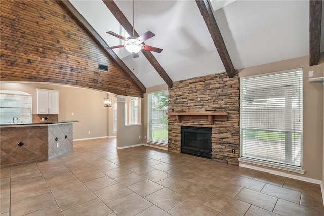23106 Willow Canyon Dr, Katy, TX 77494 - unfurnished living room featuring a ceiling fan, high vaulted ceiling, a fireplace, beam ceiling, and light tile patterned floors