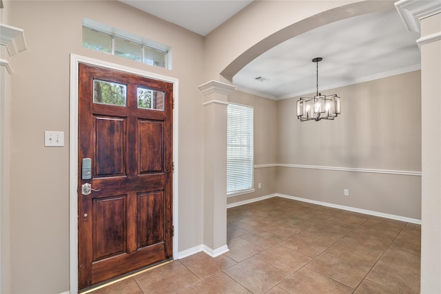 23106 Willow Canyon Dr, Katy, TX 77494 - foyer with arched walkways, tile patterned flooring, ornate columns, baseboards, and a chandelier
