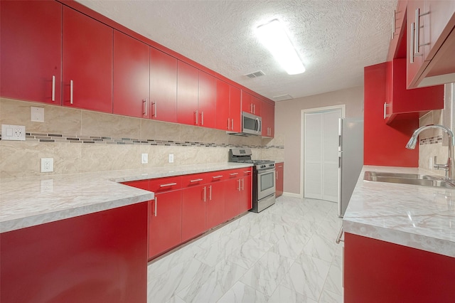 7022 Triola Ln, Houston, TX 77074 - kitchen with red cabinets, visible vents, a sink, marble finish floor, and stainless steel appliances