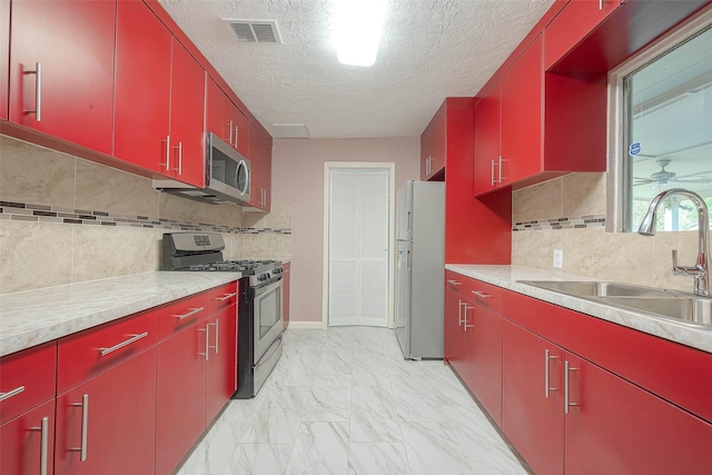 7022 Triola Ln, Houston, TX 77074 - kitchen with a sink, appliances with stainless steel finishes, red cabinets, and visible vents