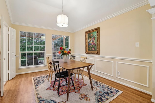 dining space with ornamental molding, wainscoting, and wood finished floors