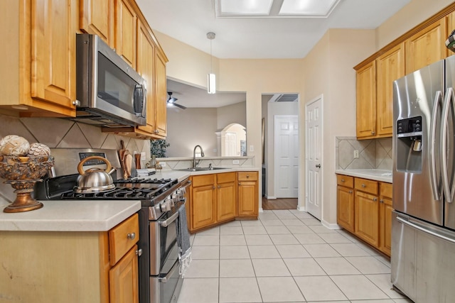 kitchen with light countertops, backsplash, appliances with stainless steel finishes, and a sink