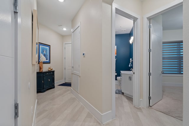 hall with light wood-type flooring, recessed lighting, and baseboards