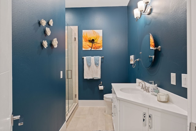bathroom featuring toilet, baseboards, a shower stall, and vanity