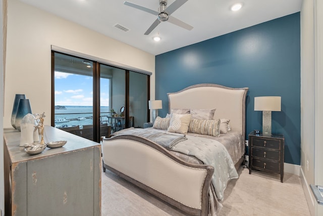 bedroom featuring ceiling fan, visible vents, a water view, light carpet, and recessed lighting