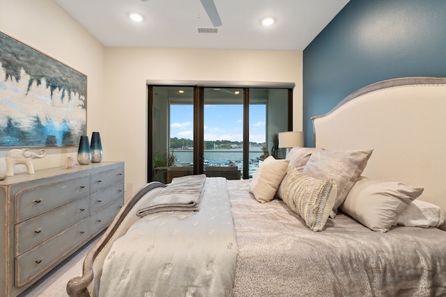 bedroom featuring access to outside, recessed lighting, a water view, and visible vents