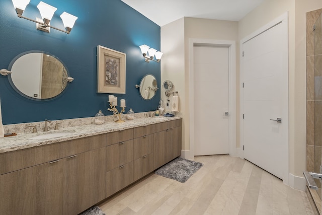 full bath with a skylight, double vanity, and a sink