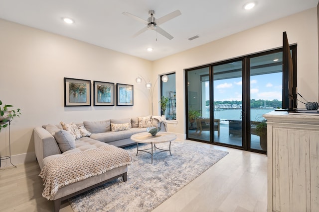 living room with light wood finished floors, a ceiling fan, baseboards, recessed lighting, and visible vents