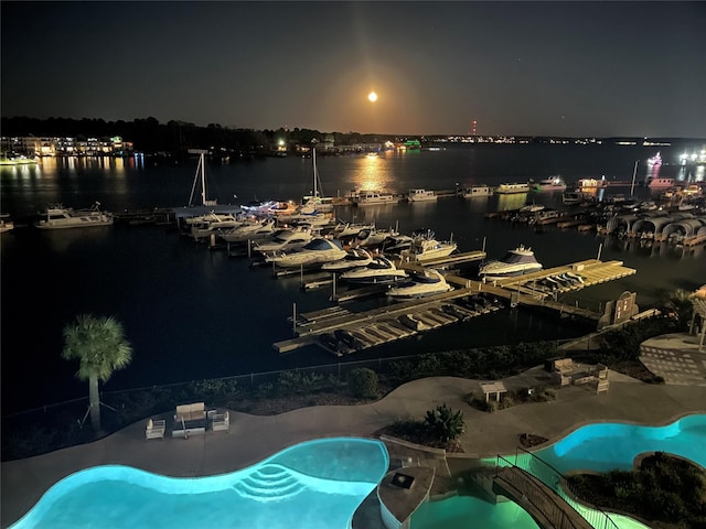 199 Waterpoint Ct Unit 309, Montgomery, TX 77356 - pool at night featuring a water view and a boat dock