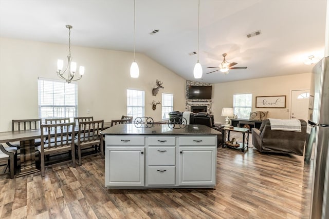 50 Canary St, Point Blank, TX 77364 - kitchen with a stone fireplace, dark countertops, vaulted ceiling, dark wood-type flooring, and plenty of natural light
