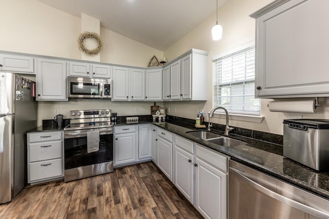 50 Canary St, Point Blank, TX 77364 - kitchen featuring appliances with stainless steel finishes, a sink, lofted ceiling, dark wood-style floors, and dark stone countertops