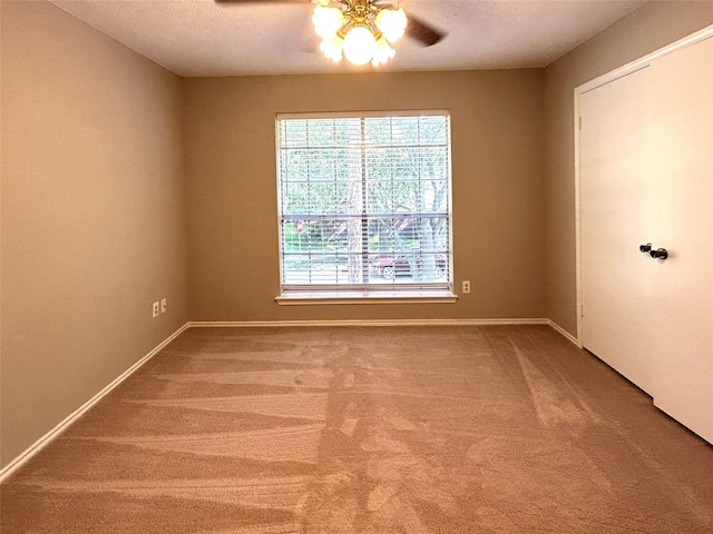 unfurnished room with a textured ceiling, ceiling fan, baseboards, and carpet