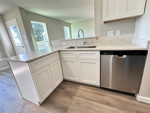 kitchen featuring a peninsula, white cabinetry, a sink, and dishwasher