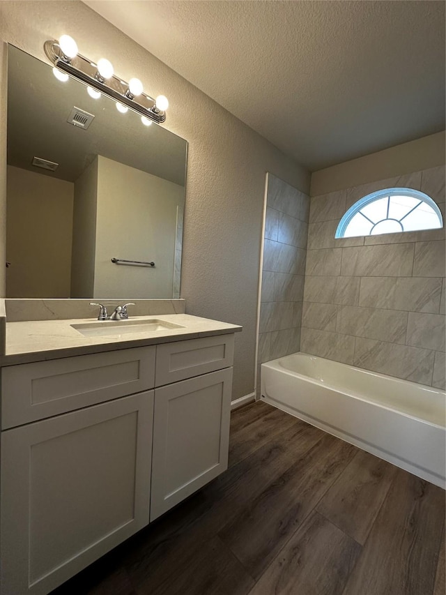 bathroom featuring vanity, visible vents, a textured ceiling, and wood finished floors