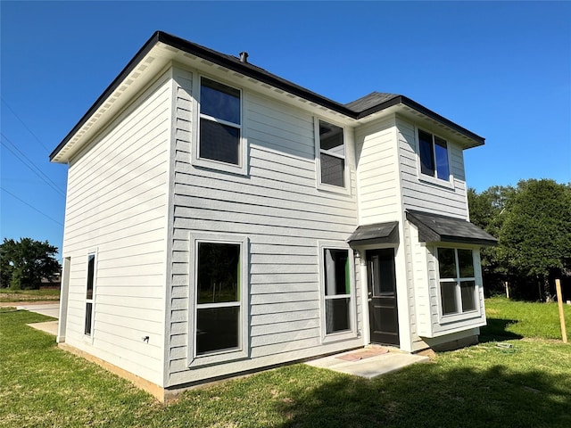 rear view of property featuring a yard