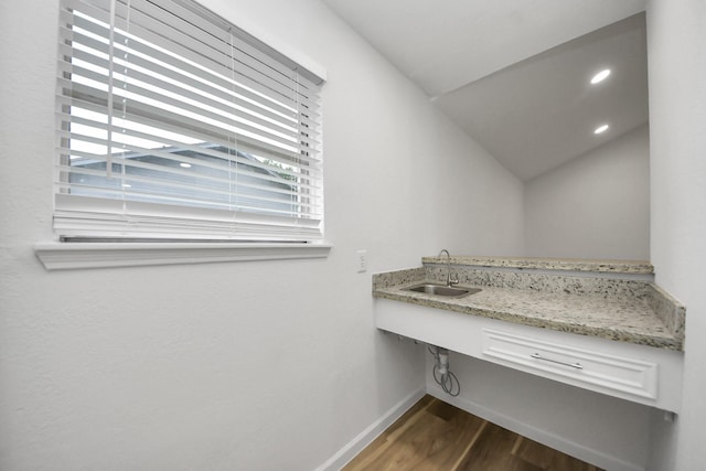 laundry room featuring dark wood finished floors, wet bar, baseboards, and recessed lighting