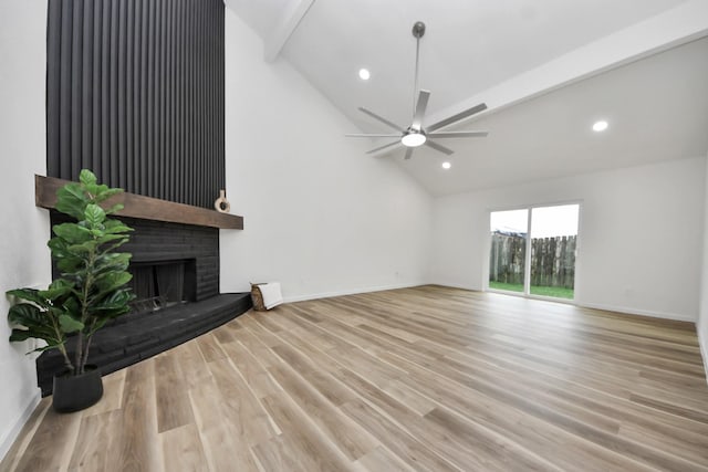 unfurnished living room featuring a fireplace, ceiling fan, high vaulted ceiling, baseboards, and wood finished floors