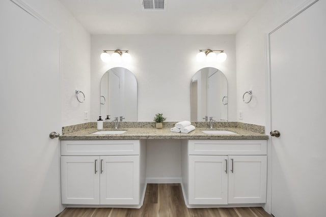 full bath featuring double vanity and wood finished floors